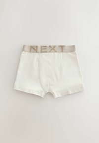 Bóxers blancos para niños con cintura elástica beige con la marca "NEXT", mostrados extendidos sobre un fondo claro.