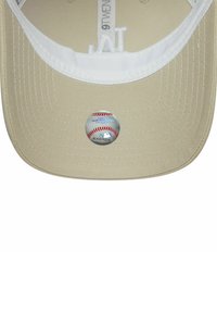 Beige Baseballcap mit einem holografischen Echtheitsaufkleber der Major League Baseball und weißem Innenfutter mit sichtbarer Naht.