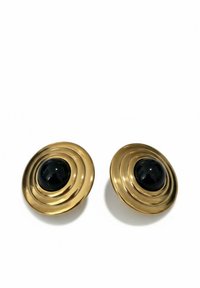 Gold-tone circular earrings featuring a raised spiral design and a central black gemstone. Smooth metallic surface, glossy texture.