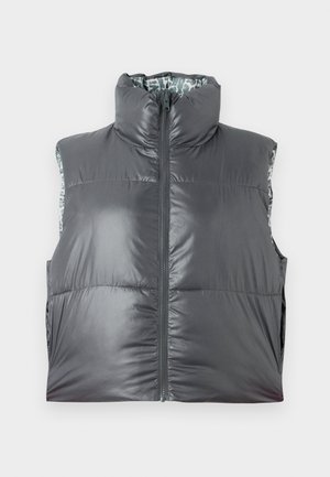 Chaleco gris acolchado con cuello alto y cremallera frontal. Presenta un exterior brillante y un forro interior con patrón. Diseño ligero y sin mangas.