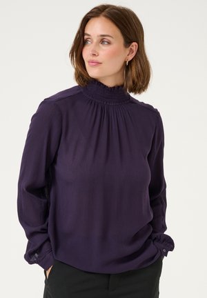 Lila Bluse mit langen Ärmeln, hohem Rüschkragen und gefälteltem Design. Besitzt einen lockeren Schnitt und Knopfakzente an den Bündchen.