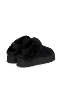 Scarpe slip-on nere con un morbido rivestimento in pelliccia, tomaia in camoscio, suola in gomma spessa e cuciture decorative lungo il bordo.