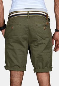 Olivgrüne Baumwollshorts mit umgeschlagenem Saum, zwei Gesäßtaschen und einem mehrfarbigen gestreiften elastischen Bund.