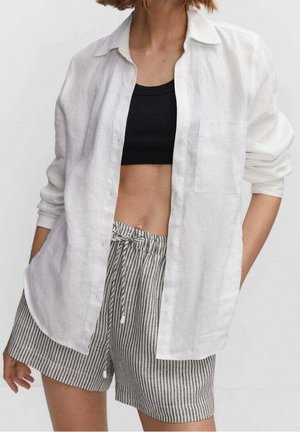 White linen button-up shirt with rolled sleeves, paired with gray striped shorts featuring a drawstring waist.