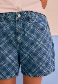 Denim shorts met een lichtblauw geruit patroon, voorzien van een knoopsluiting, twee zakken aan de voorkant en een licht gefranjerde zoom.