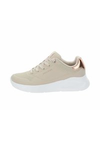 Zapatillas deportivas beige con un upper sintético suave, acentos perforados, suela blanca y detalle en el talón de oro rosa metálico. Diseño clásico con cordones.