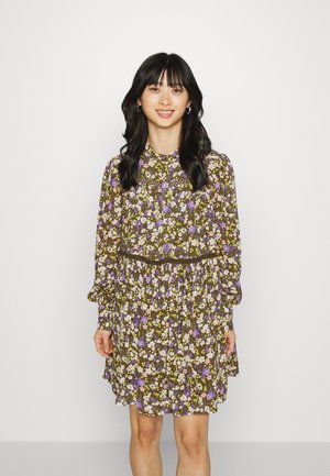 Vestido floral com base castanha, apresentando flores coloridas roxas e brancas, mangas longas, cintura franzida e comprimento até ao joelho.
