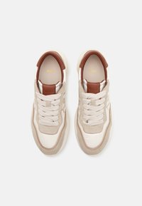 Paire de baskets beige et blanches avec des accents marron, des lacets crème, et le logo "BOSS" sur la languette et les semelles, vue de dessus.