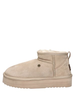 Beige suède enkelboot met een ronde neus, zachte fleece voering en een gestructureerde rubberen zool. Voorzien van een achtertab voor eenvoudig aan- en uittrekken.