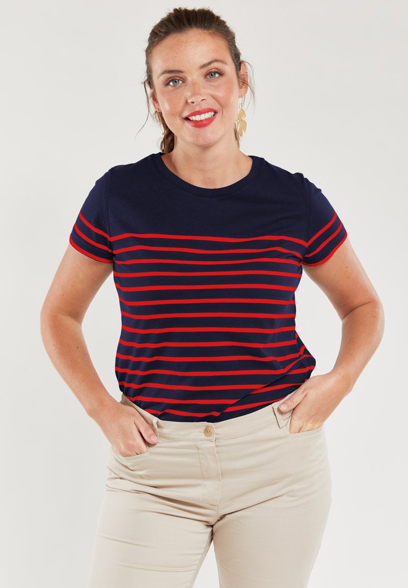 Granatowy t-shirt w poziome czerwone paski, krótki rękaw, okrągły dekolt i gładka faktura, w połączeniu z beżowymi spodniami.