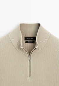 Khaki knit pullover with a quarter-zip front.  Ribbed texture, wide collar, and label visible inside. Made from 100% cotton.