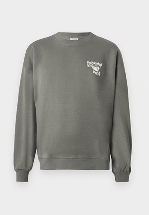 Grå genser med rund hals, ribbestrikkede cuffs og hem, med liten hvit "Daily Grind NYC"-tekst og tegneseriestyle kaffekoppgrafikk på brystet.