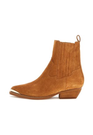 Stivale alla caviglia in suede marrone con punta affusolata, accenti di cuciture verticali e una punta in metallo argentato. Design con tacco basso impilato.