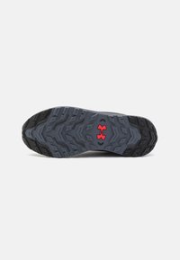 Talpa de pantof sport cu o suprafață texturată din cauciuc gri, cu accente negre și un logo roșu, proiectată pentru aderență și durabilitate.