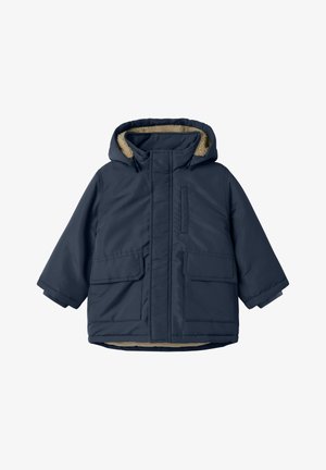 Giacca trapuntata blu navy con cappuccio foderato in pelliccia, due tasche frontali e chiusura con zip. Texture liscia con finitura opaca.