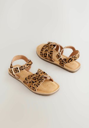 Sandalias marrones con estampado de leopardo, múltiples tiras ajustables, textura suave de ante, suela plana y un adorno de hebilla dorada.