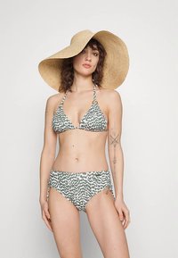 Grønn og hvit mønstret bikini med trekantet topp og midjehøy bunn, med sidetilknytninger, og en bred stråhatt.