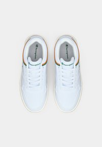 Λευκά αθλητικά παπούτσια με λείο συνθετικό επάνω μέρος, πράσινες και πορτοκαλί λεπτομέρειες, σχέδιο με κορδόνια και υφή στη σόλα από καουτσούκ.