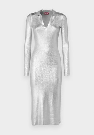 Sidabrinė metalinė suknelė su apykakliniu dekolte, ilgomis rankovėmis ir prigludusia siluetu. Audinys turi tekstūruotą, blizgančią apdailą.