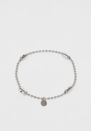 Pulsera de cadena de bola plateada con acentos pulidos y un pequeño charm circular. Presenta una textura suave y un diseño simple y redondeado.
