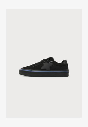 Fekete alacsony szárú Hugo sneaker fűzős elülső résszel, csillag részlettel az oldalon, kék szegéllyel a talpon és márkázott logóval a boka környékén.