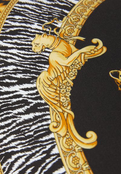 Black fabric with yellow and gold ornate patterns, featuring a stylized animal design and contrasting zebra stripes.