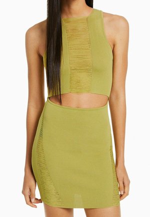 Haut court sans manches vert olive et mini-jupe taille haute assortie avec des détails texturés verticaux usés.