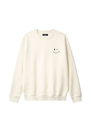 Bluză cu guler rotund de culoarea cremei, cu un mic emoticon negru zâmbitor, un ochi deschis și unul încrucișat, pe partea stângă a pieptului.