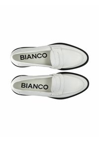 Scarpe slip-on in pelle bianca con suola nera a contrasto. Presentano una punta arrotondata, dettagli cuciti e una texture morbida. Marchio visibile all'interno.