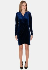 Abito avvolgente in velluto blu navy con maniche lunghe, scollatura a V e silhouette aderente, caratterizzato da dettagli arricciati in vita.