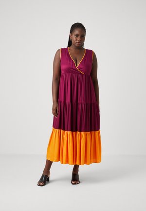 Lang kjole med dyp V-hals, ermeløs design, laget i lag med en øverste del i mørk burgunder og en nederste del i lys oransje.