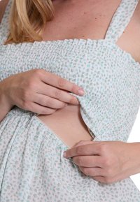 Rosa und grün gemustertes Kleid mit gerafftem Oberteil und verstellbaren Trägern; das Model passt den seitlichen Reißverschluss für eine optimale Passform an. Weiches, leichtes Material.