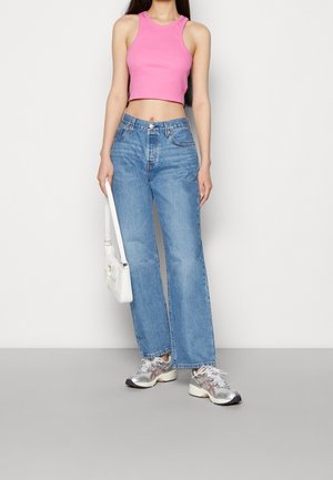 Rosa kort linne, blå jeans med vida byxben, silverfärgade sneakers med detaljer och en vit axelväska. Enkel och funktionell outfit.