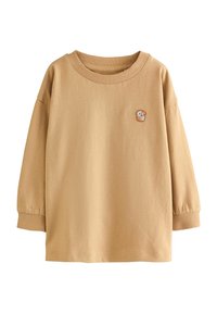 Ljusbrun långärmad skjorta med en liten broderad bild av en brödlimpa på bröstet, samt en enkel ribbad krage.