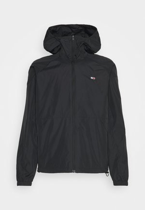 Schwarze leichte Kapuzen-Windjacke mit Frontreißverschluss, elastischen Bündchen, Seitentaschen und kleinem rechteckigem Logo auf der linken Brust.