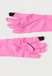 Svetlo roza rokavice s črnimi nasveti za zaslon na dotik na palcu in kazalcu, razporejene na belem površju.