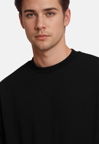 Schwarzer Baumwoll-Sweatshirt mit Rundhalsausschnitt, der eine glatte Textur und ein schlichtes Design aufweist. Keine sichtbaren Muster oder Hardware-Details.