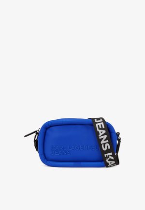 Borsa rettangolare blu realizzata in materiale imbottito, dotata di chiusura con zip. Ha una tracolla nera con la scritta "JEANS" e il nome del marchio in rilievo sul davanti.