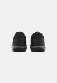 Schwarze Sportschuhe mit einem Mesh-Obermaterial, geschwungenem Fersendesign, texturierter Sohle und grauen Akzenten, von hinten betrachtet.