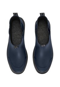 Zapatos de lona azul marino, con un acabado liso y brillante, que cuentan con un suave interior de fieltro gris y una suela de goma negra. Elementos de diseño minimalistas.