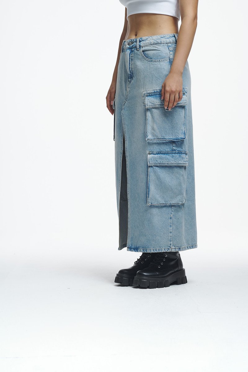Svetlo modra denim maksi krila z sprednjim razporkom, več cargo žepi in raztrganim robom, v kombinaciji z črnimi debelimi čipkastimi škornji.
