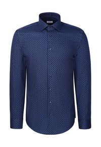 Chemise homme à manches longues boutonnée avec un petit motif géométrique bleu et noir et un col pointu sur fond blanc.