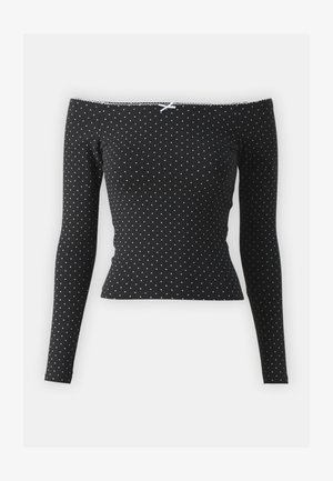 Čierny top bez ramienok s dlhými rukávmi, zdobený bielymi bodkami a dekoratívnou mašľou na krku, vyrobený z mäkkého a elastického materiálu.
