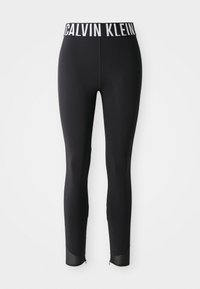 Leggings noirs ajustés avec une taille élastique à logo Calvin Klein blanc et des panneaux en mesh aux ourlets des chevilles sur fond blanc.