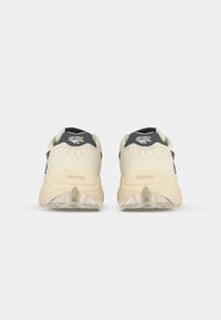 White and navy sports shoes featuring a breathable upper, cushioned sole, and textured outsole with "Vibram" branding on the heel.
