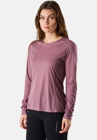 Langarm sportshirt in stofroze met een gestructureerd patroon, ronde halslijn en duimgaten in de mouwen. De stof lijkt lichtgewicht en ademend te zijn.