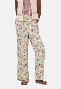 Pantalones de pierna ancha en tela ligera, con un estampado colorido de flores y aves sobre un fondo crema. Detalle de cintura con cordón.