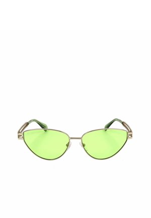 Occhiali da sole a occhio di gatto con sottili montature metalliche dorate e lenti traslucide verde brillante su sfondo bianco.