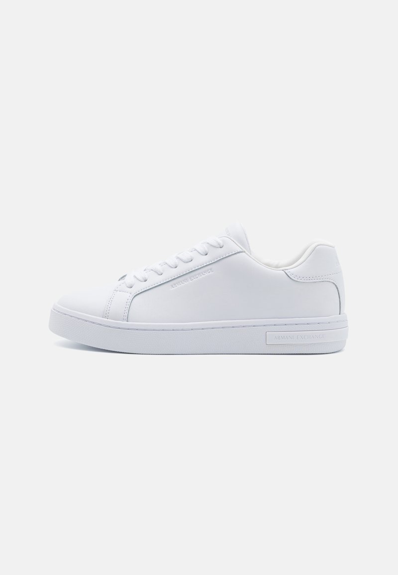 White leather low-top sneakers with round toe, flat rubber sole, and logo detail on the side. Features six pairs of eyelets and textured accents.