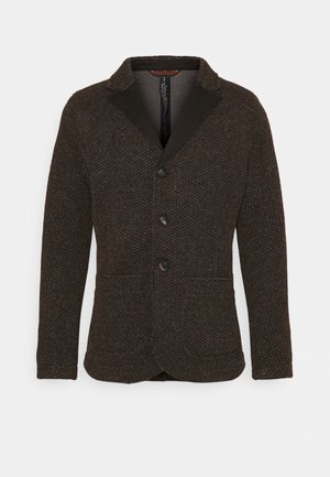 Bruine textuurjas met een ingesneden kraag, drie knopen en twee voorzakken. Gemaakt van een geweven stof met subtiele patroon details.